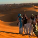 Sahara Dune Group Women Sunset — Morocco Epic Journey guided Morocco tours across the Sahara desert, kasbahs and imperial cities.