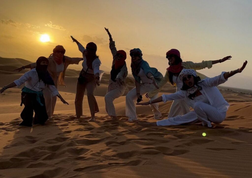 Sahara dunes group sunset celebration, Morocco