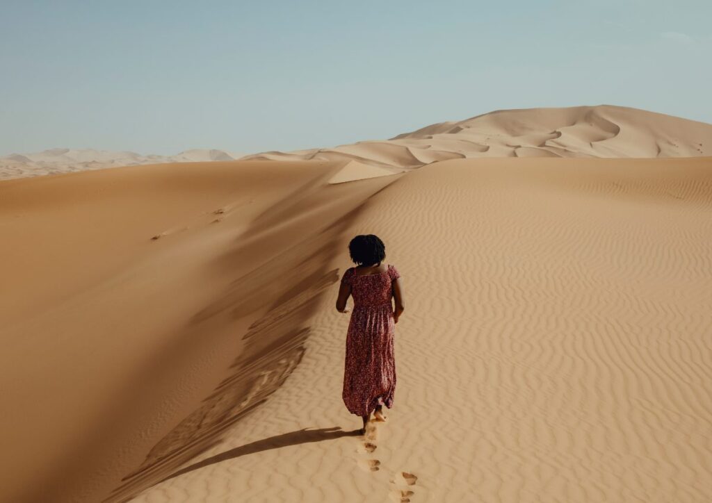 Woman walking Sahara dune, Morocco